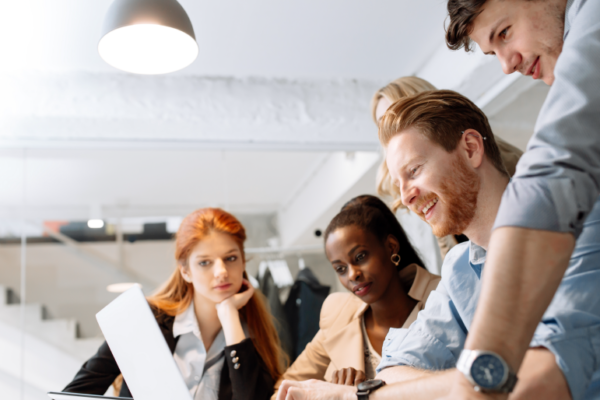 employees huddled around a laptop screen discussing a credit-based Health Spending Account